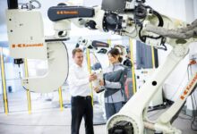 a man and a woman standing in front of a robot