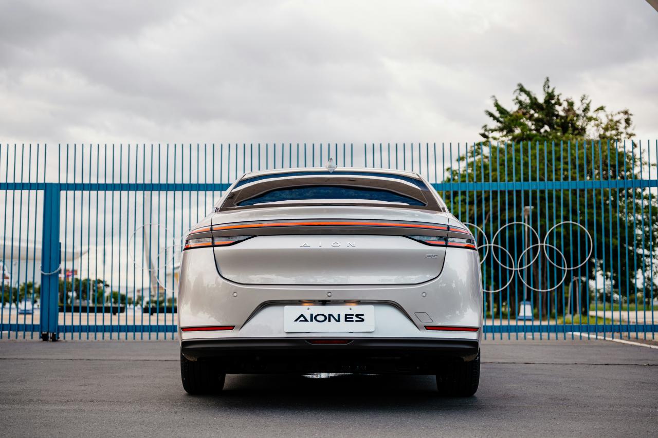 Rear view of a silver electric car with olympic rings.