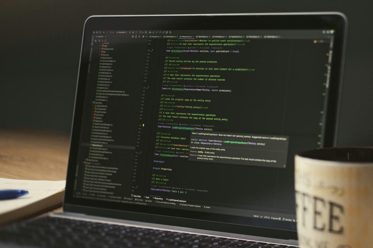 Laptop screen displaying lines of code with a coffee mug